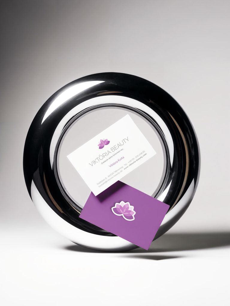 Visitenkarten von Viktoria Beauty in einem glänzenden, runden Ständer.